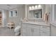 Bright bathroom with white vanity, quartz countertop, decorative mirror and gray wood-look tile flooring at 2558 Premier Pl, Boulder, CO 80304