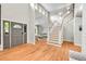 Bright foyer featuring a staircase, hardwood floors, a large front door, and an adjacent sitting room at 2558 Premier Pl, Boulder, CO 80304