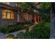 Home exterior featuring an arched porch, lush landscaping, stone pathway, and mature trees at 2558 Premier Pl, Boulder, CO 80304