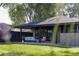 Covered backyard patio featuring comfortable seating and well manicured lawn at 199 S Ivy St, Denver, CO 80224