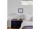 Cozy bedroom featuring a minimalist design with a dark wood nightstand, lamp, and a framed artwork on the white wall at 199 S Ivy St, Denver, CO 80224