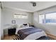 Bright bedroom with a queen-sized bed, striped rug, and large windows, showcasing a minimalist aesthetic at 199 S Ivy St, Denver, CO 80224