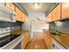 View of galley kitchen with appliances and light wood cabinets at 7335 E Quincy Ave # 303, Denver, CO 80237