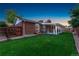 Brick home features a lush green back yard with a covered patio for relaxation and outdoor entertainment at 12906 Cherry Way, Thornton, CO 80241