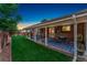 Covered backyard patio with a dining table, BBQ and well-maintained lawn, ideal for outdoor entertaining and leisure at 12906 Cherry Way, Thornton, CO 80241