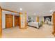 Spacious basement bedroom with carpet and finished ceiling, featuring an adjacent seating area and multiple closets at 12906 Cherry Way, Thornton, CO 80241