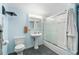 Bathroom with pedestal sink, toilet, and a sliding glass door shower/tub combination, creating a functional space at 12906 Cherry Way, Thornton, CO 80241