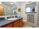 Traditional bathroom featuring a wood vanity, mirror, toilet, and tiled shower with a blue and white curtain at 12906 Cherry Way, Thornton, CO 80241