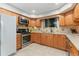 Traditional eat-in kitchen featuring wooden cabinetry, stainless steel appliances, and tile backsplash at 12906 Cherry Way, Thornton, CO 80241
