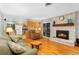 Open living room with kitchen and fireplace features hardwood floors and access to backyard at 12906 Cherry Way, Thornton, CO 80241