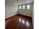 Bedroom featuring wood laminate flooring and three windows at 1129 S Duquesne Cir, Aurora, CO 80018