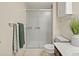 Bathroom featuring shower with glass doors, cabinet, toilet, and green and gray towels at 3470 S Poplar St. # 110, Denver, CO 80224
