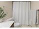 Bright bathroom featuring a white shower curtain, toilet, white countertop, and gray towels at 3470 S Poplar St. # 110, Denver, CO 80224