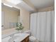 Bathroom featuring a shower with white curtain, toilet, white countertop, and a wood cabinet at 3470 S Poplar St. # 110, Denver, CO 80224