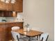 Cozy dining area with wood table and chairs adjacent to the kitchen with wooden cabinets at 3470 S Poplar St. # 110, Denver, CO 80224