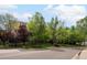 Exterior view of the building with manicured lawns and green trees alongside the street at 3470 S Poplar St. # 110, Denver, CO 80224