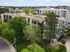 Exterior of a building with lovely green trees and landscaped lawn on a sunny day at 3470 S Poplar St. # 110, Denver, CO 80224