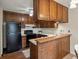 Kitchen with wood cabinets, functional appliances, and a breakfast bar at 3470 S Poplar St. # 110, Denver, CO 80224
