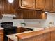 Kitchen featuring wood cabinetry, an electric range, and ample counter space at 3470 S Poplar St. # 110, Denver, CO 80224