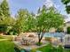 Outdoor pool area with lounge chairs, picnic tables, and beautiful trees for shade on a sunny day at 3470 S Poplar St. # 110, Denver, CO 80224
