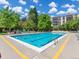 Outdoor swimming pool with blue water, surrounded by chairs, mature trees, and lovely sky at 3470 S Poplar St. # 110, Denver, CO 80224