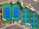Aerial view of tennis and pickleball courts with blue and green surfaces, surrounded by trees and landscaping at 7560 S Biloxi Ct, Aurora, CO 80016