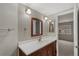 Bathroom featuring a single sink vanity, a framed mirror, and view to bedroom at 7560 S Biloxi Ct, Aurora, CO 80016
