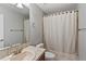Bright bathroom featuring a tub with shower curtain, a tiled sink, and ample lighting at 7560 S Biloxi Ct, Aurora, CO 80016
