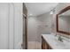 Bathroom featuring a single sink vanity, a framed mirror, and a glass door shower stall at 7560 S Biloxi Ct, Aurora, CO 80016
