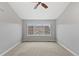 Bedroom features a ceiling fan, window view of neighborhood, and neutral décor at 7560 S Biloxi Ct, Aurora, CO 80016