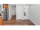 Hallway featuring wood floors, white doors, and stainless-steel refrigerator at 7560 S Biloxi Ct, Aurora, CO 80016
