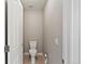 Powder room featuring toilet, neutral decor, and tiled flooring at 7560 S Biloxi Ct, Aurora, CO 80016