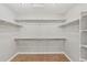 Bright, walk-in closet featuring ample shelving and a plush, neutral-toned carpet at 7560 S Biloxi Ct, Aurora, CO 80016