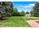 Expansive backyard featuring a lush lawn, mature trees, a swing set, and a storage shed for outdoor activities at 6755 W 45Th Ave, Wheat Ridge, CO 80033