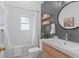 Stylish bathroom with modern sink, toilet, bathtub and dark gray accent wall at 6755 W 45Th Ave, Wheat Ridge, CO 80033