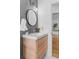 Modern bathroom featuring a stylish vanity with a round mirror and open door to a bright interior at 6755 W 45Th Ave, Wheat Ridge, CO 80033