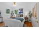 Bright bedroom with wood floors, white walls, a queen bed, two windows and plants for a touch of nature at 6755 W 45Th Ave, Wheat Ridge, CO 80033