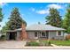 Charming single-story home featuring a brick chimney, a well-kept lawn, and beautiful landscaping at 6755 W 45Th Ave, Wheat Ridge, CO 80033
