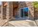 Stone facade with a sliding glass door leading to a concrete patio, offering a private outdoor space at 7580 S Biloxi Ct, Aurora, CO 80016