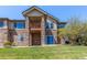 Spacious backyard with a stone exterior, a balcony, and a well-maintained lawn at 7580 S Biloxi Ct, Aurora, CO 80016