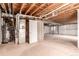 Unfinished basement space with exposed ceiling, mechanicals, and carpeted flooring, ready for customization at 7580 S Biloxi Ct, Aurora, CO 80016