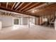 Unfinished basement with exposed ceiling, concrete floor and walkout door at 7580 S Biloxi Ct, Aurora, CO 80016