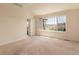 Bright bedroom with neutral carpet, large window with neighborhood view, and white trim at 7580 S Biloxi Ct, Aurora, CO 80016