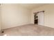 Spacious bedroom with plush carpet and sliding barn door to ensuite bathroom at 7580 S Biloxi Ct, Aurora, CO 80016