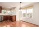 Open dining area with hardwood floors, modern light fixture, many windows, and view of the kitchen at 7580 S Biloxi Ct, Aurora, CO 80016