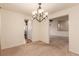Bright dining room showcasing an elegant chandelier, neutral carpet, and easy access to the kitchen at 7580 S Biloxi Ct, Aurora, CO 80016