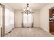Bright dining room featuring an elegant chandelier, neutral carpet, and ample natural light at 7580 S Biloxi Ct, Aurora, CO 80016