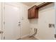 Laundry room with tile flooring, cabinet, and white door at 7580 S Biloxi Ct, Aurora, CO 80016