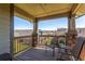 Relaxing covered patio with wood flooring, stone pillars, comfortable seating, and neighborhood views at 7580 S Biloxi Ct, Aurora, CO 80016