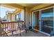Relaxing covered patio with wood flooring, comfortable seating, and sliding glass door to enter house at 7580 S Biloxi Ct, Aurora, CO 80016